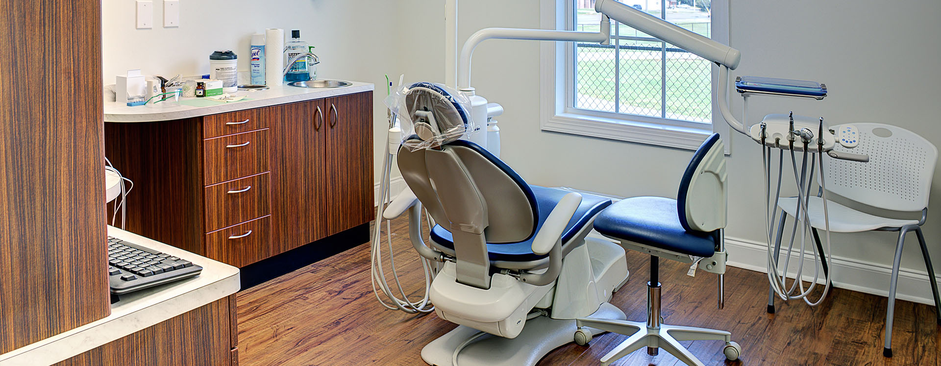 The image shows a dental office interior with dental chairs, a reception desk, and dental equipment visible.